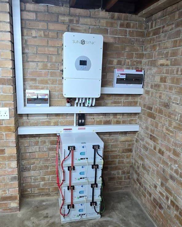 Inverter above a stack of batteries on a brick wall