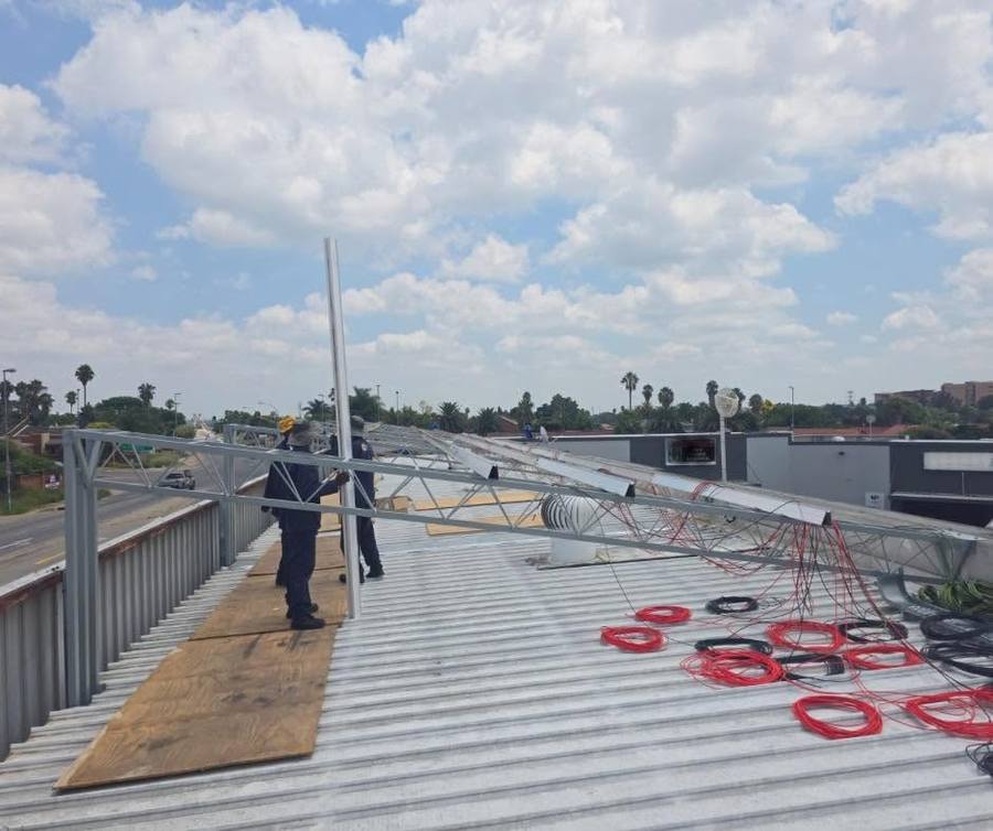 Installer on a roof beside a solar mounting frame